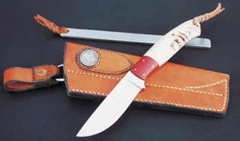 Forged hunter, ram's horn handle, red micarta bolster, sheath with sharpening steel.